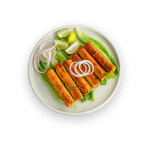 Plate of golden brown Chicken Seekh Kebabs with onion and lemon. Best frozen kebab delivery in Seohara.