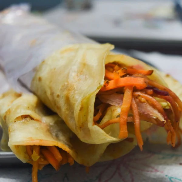 Veg Masala Roll Wrap Veg masala roll cut in half showing crispy filling on a dark background - Seohara Kitchen