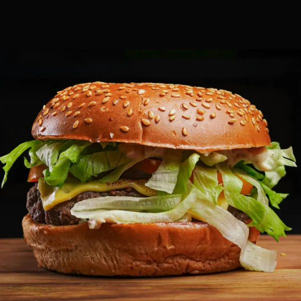 Classic aloo tikki burger with onion tomato and mayo on dark background - Seohara Kitchen